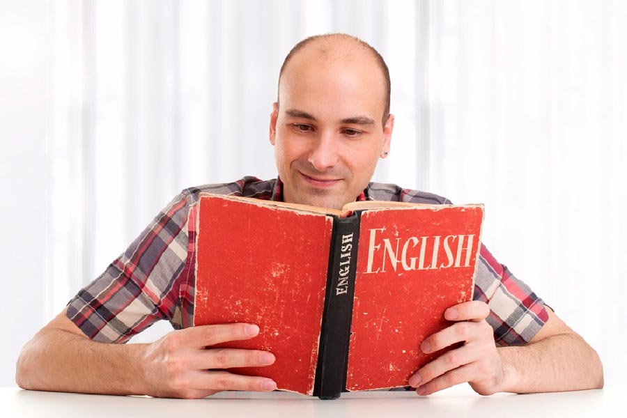Мужчина читает учебник по английскому языку